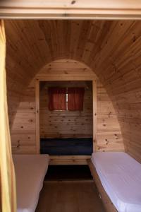 a bedroom in a log cabin with two beds at Camping Dolce Sole in Marina di Massa