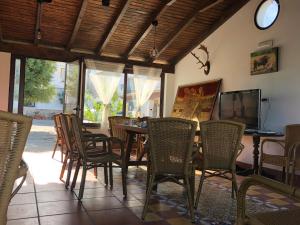 ein Esszimmer mit Stühlen, einem Tisch und einem TV in der Unterkunft Alojamiento Rural El Soldao in Medina-Sidonia