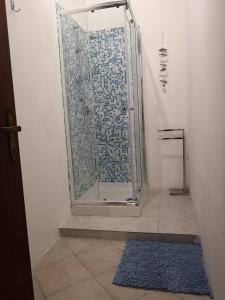 y baño con ducha y alfombra azul. en Le Casette, en Guardistallo