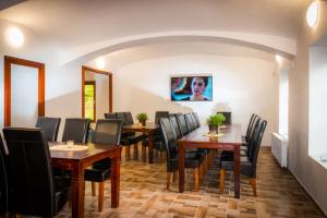 a dining room with wooden tables and black chairs at Penzion Sloup in Sloup