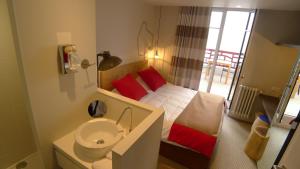 a small bathroom with a bed and a sink at Hôtel Ar Iniz in Saint Malo