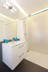 a white bathroom with a sink and a shower at Domki Amare in Pobierowo +16 photos