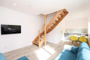 a living room with a blue couch and a staircase at Amare Domki in Pobierowo
