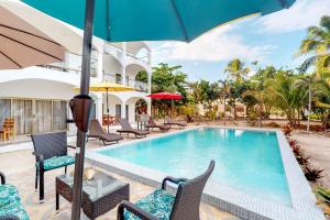 a pool at a resort with chairs and umbrellas at Blue Water Beach Villas in San Pedro