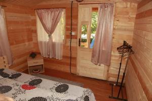 a bedroom of a log cabin with a bed and a window at Casa Ysa in Vama Veche +18 photos