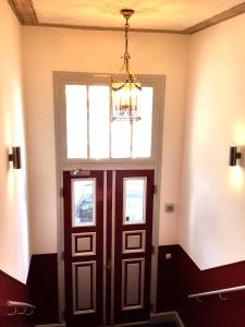 eine Tür in einem Zimmer mit einem Fenster und einem Kronleuchter in der Unterkunft Apartments Harmsstraße 13 in Kiel