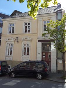 una macchina nera parcheggiata di fronte a una casa di Apartments Harmsstraße 13 a Kiel