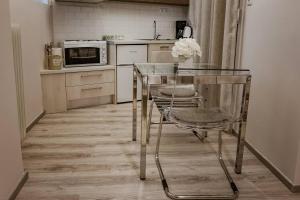 eine Küche mit einem Glastisch und Stühlen in der Unterkunft Country Chic in Ioannina city center in Ioannina