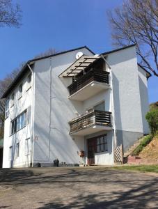 a white building with stairs on the side of it at Ferienwohnung Im Bachgrund in Schlitz