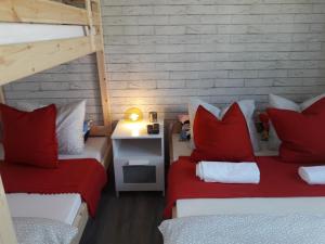 ザトルにあるDobranocka - pokoje i całoroczne domki blisko Energylandiiの赤い枕と二段ベッド2台が備わる客室です。