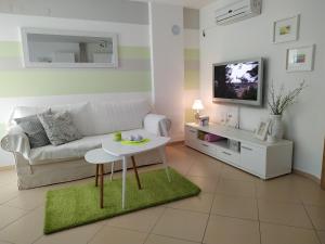 uma sala de estar com um sofá branco e uma mesa em Apartment - Ivo em Čižići