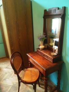 a wooden table with a mirror and a chair at AMBROsador in Ambrolauri