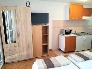 Cette petite chambre comprend une cuisine équipée d'un four micro-ondes. dans l'établissement DCK Apartments, à Kostrena