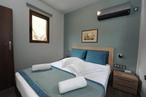 a bedroom with a white bed and a blue wall at Castle View Bungalows in Mystras
