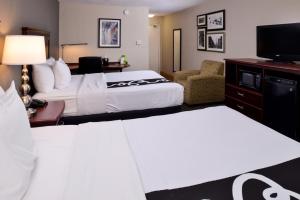 a hotel room with two beds and a flat screen tv at La Quinta by Wyndham Indianapolis South in Indianapolis