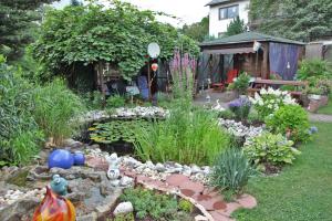 un jardín con un estanque y un jardín con flores en Ferienwohnung Sauer, en Hillscheid