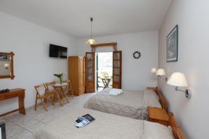 Habitación con 2 camas y mesa con escritorio. en Thalassia Thea, en Galissas