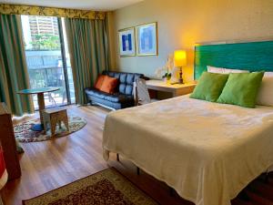 Un dormitorio con una cama grande y una sala de estar en Palms Waikiki #412, en Honolulu 26 fotos más