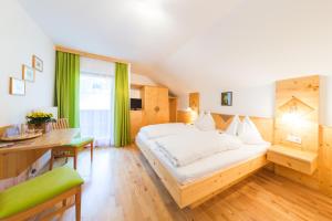 - une chambre avec un lit blanc, un bureau et une fenêtre dans l'établissement Kristemoarhof, à Lavant