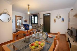 eine Küche und ein Wohnzimmer mit einem Tisch und einer Obstschale in der Unterkunft Buda in Tinajo