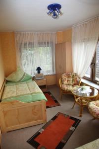 HillscheidにあるFerienwohnung Sauerのベッドルーム1室(ベッド1台、椅子、テーブル付)