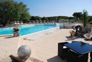 a patio with a pool and a table and chairs at Residence Ribellinu in Pianottoli-Caldarello