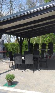 - un groupe de chaises et une table sous un pavillon dans l'établissement Domki w BOSZKOWIE, à Boszkowo