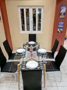 mesa de comedor con sillas negras y mesa de cristal en Georgia Seaside Villa, en Hersonissos