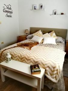 Un dormitorio con una cama y una mesa con un libro en La casa de la abuela, en San Lorenzo
