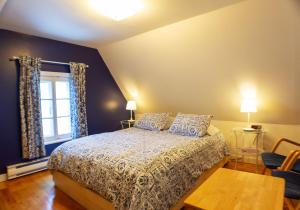 a bedroom with a bed and a window at Auberge La Marmite in La Malbaie