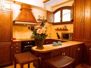 a kitchen with a table with a vase of flowers on it at Casa Miñón in Buera