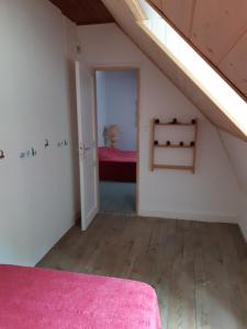 a attic room with a pink bed and a bedroom at Appartements à la Bourboule in La Bourboule