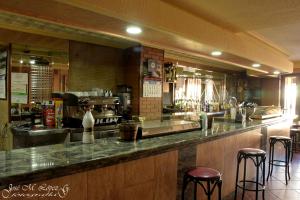 a bar in a restaurant with bar stools at Hostal Restaurante El Final in El Cabaco