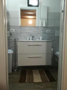 a bathroom with a white sink and a toilet at Dimora alla Chiesa Diruta in Grottole +44 photos