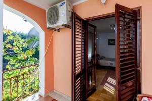 a room with a balcony with a fan and a window at Apartments Ruza in Budva