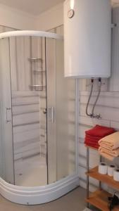 a shower with a glass door in a bathroom at Rooms & Apartment Jozić in Prozor