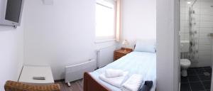 a small bedroom with a bed and a mirror at Apartments&Rooms Mido in Visoko