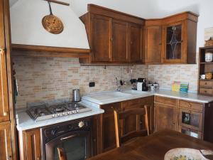 uma cozinha com armários de madeira e um forno com placa de fogão em Casa vacanza Laila em Cassina deʼ Pecchi
