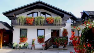 a white house with flowers on the balcony at Garden Apartments Janša in Radovljica