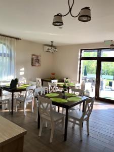 a dining room with two tables and white chairs at Villa Ciao - Adults Only in Corbu