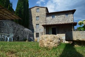 a stone house with a rock in the yard at La Calona in Camaiore