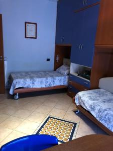 a room with two beds and a tile floor at Casa di Antonello in Cosenza