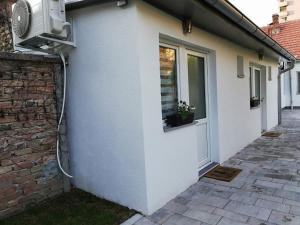 a white house with a window and a door at Rooms Jelena in Zrenjanin