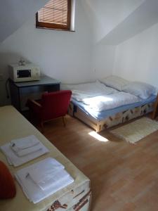 a bedroom with two beds and a desk and a chair at Apartmán Monika in Veľký Meder