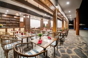 un restaurante con mesas y sillas en una habitación en Mai Chau Mountain View Resort, en Mai Chau