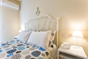 White Coral Rooms self check-in في ألغيرو: غرفة نوم بها سرير مع اللوح الأمامي الأبيض والمصباح +12 صورة