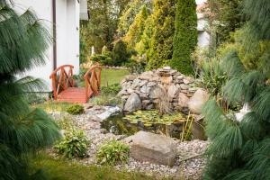 a garden with a pond and a wooden bridge at Motelik Julia in Siedlce