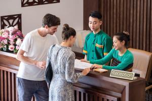 un grupo de personas de pie alrededor de un despachador en Mai Chau Mountain View Resort en Mai Chau