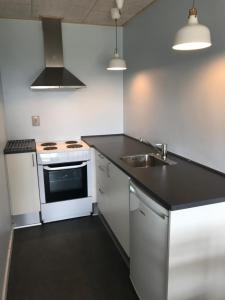 uma cozinha com um fogão branco e um lavatório em Søndervig Camping & Cottages em Søndervig