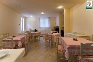 una sala da pranzo con tavoli e sedie con tovaglie rosa di Il Giardino Delle Sete a Mesagne